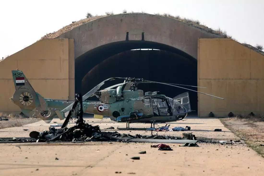 Questa immagine mostra un elicottero dell'esercito siriano bruciato dopo gli attacchi israeliani che avrebbero preso di mira i depositi di armi vicino alla base aerea militare di Mezzeh, fuori Damasco