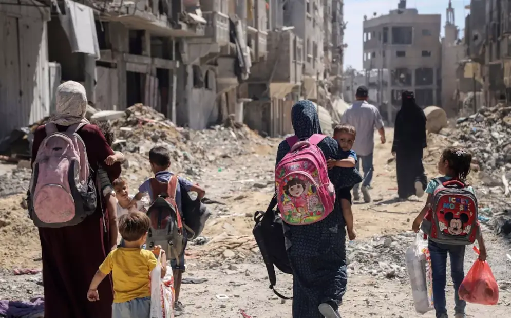 palestinesi camminano nella Gaza in rovina