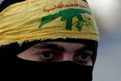 Libano terrorista di Hezbollah con fascia gialla e logo